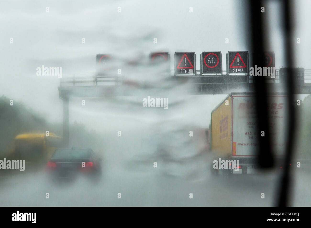 car drives, during a heavy rain storm on a highway, windshield wipers