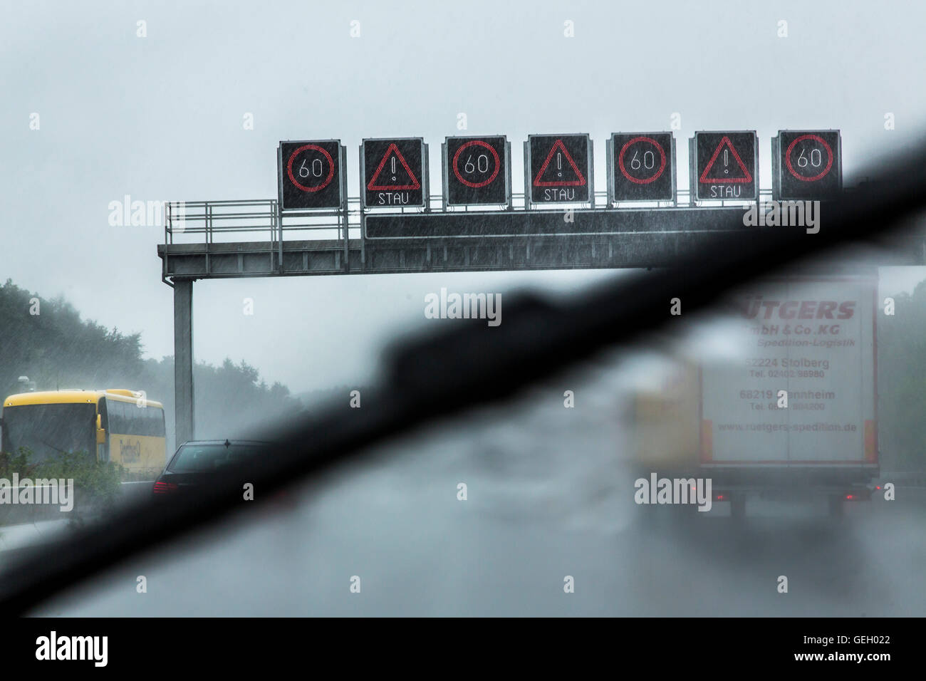 car drives, during a heavy rain storm on a highway, windshield wipers