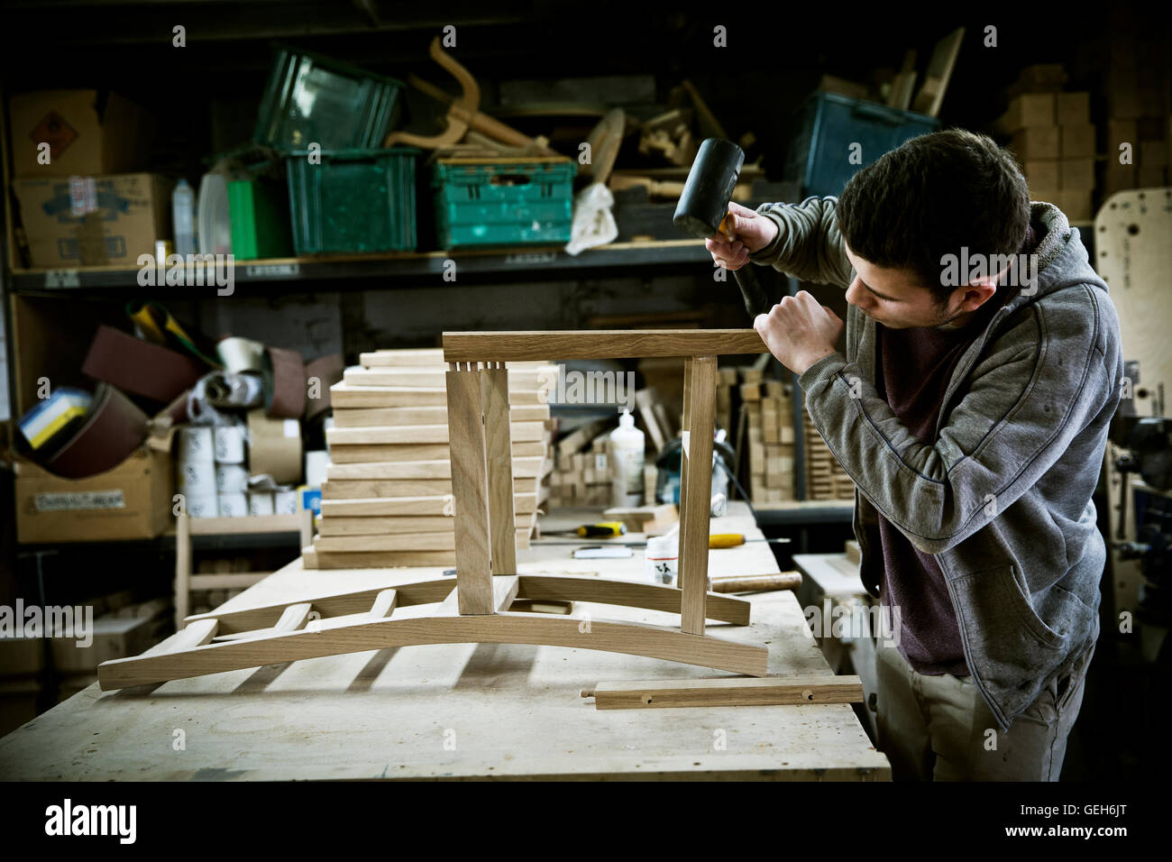 A man working in a furniture maker's assembling a chair Stock