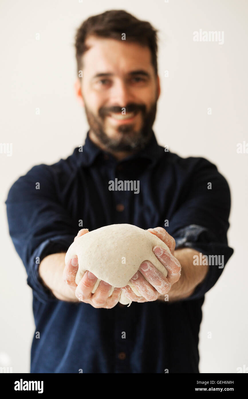 Baker holding a portion of bread dough shaped into a ball Stock Photo