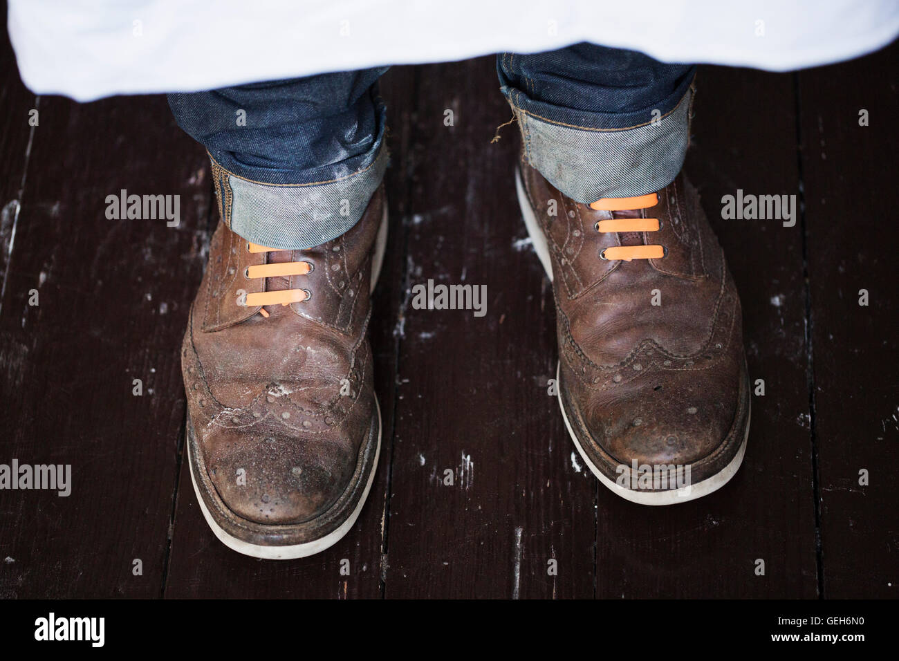 Close up of a man's feet, wearing brown shoes with orange shoe laces. Stock Photo