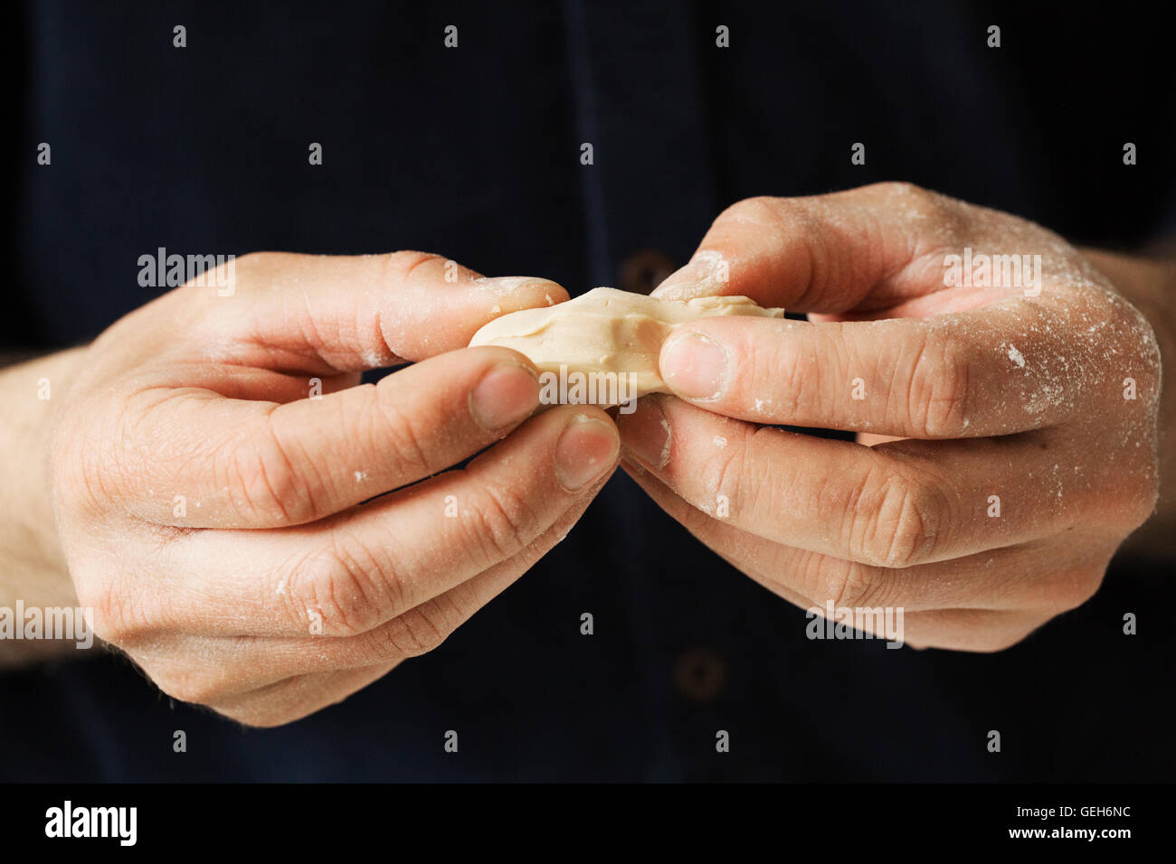 Close up of a baker holding pieces of fresh yeast in his hands. Stock Photo