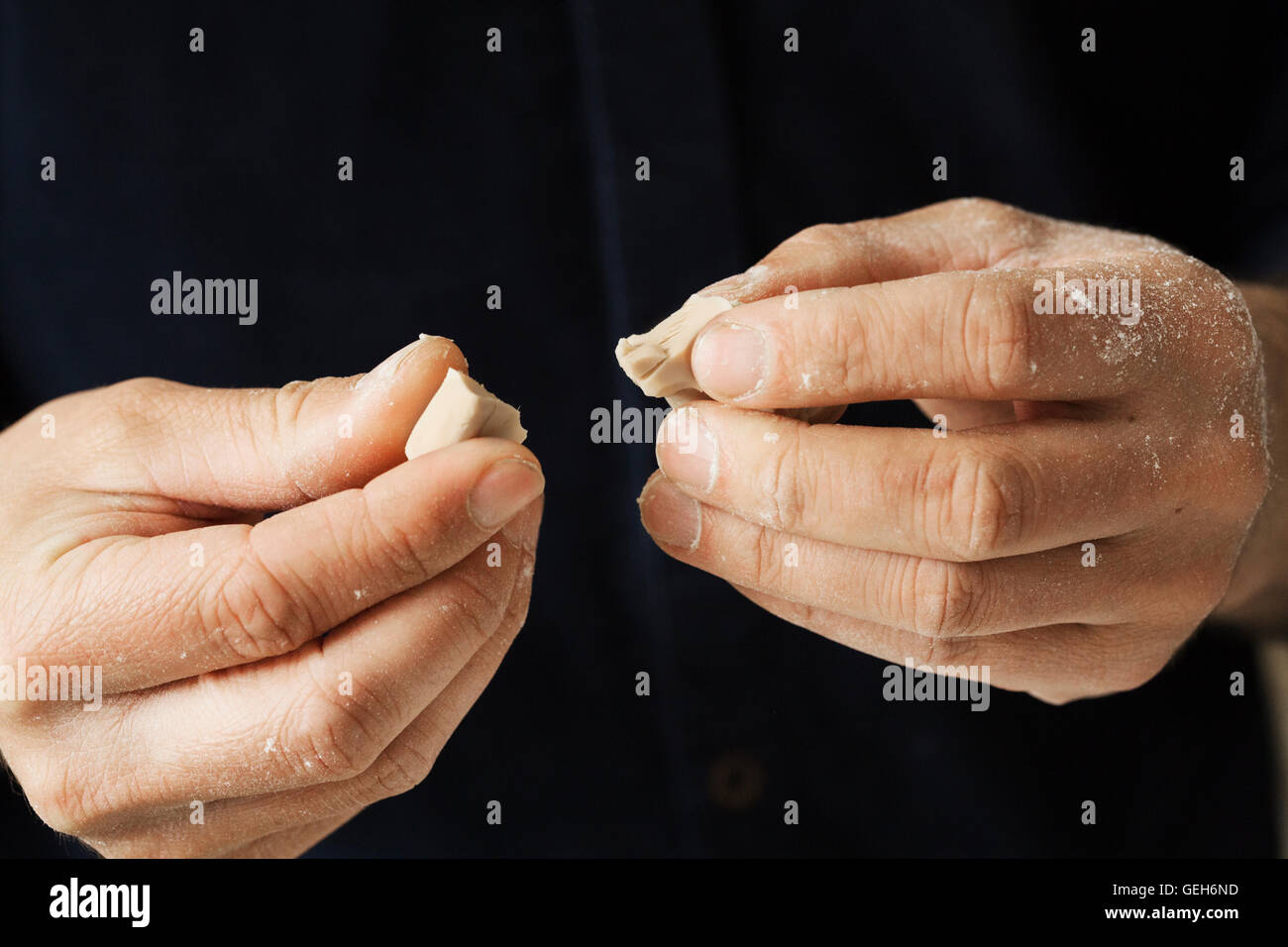 Close up of a baker holding pieces of fresh yeast in his hands. Stock Photo