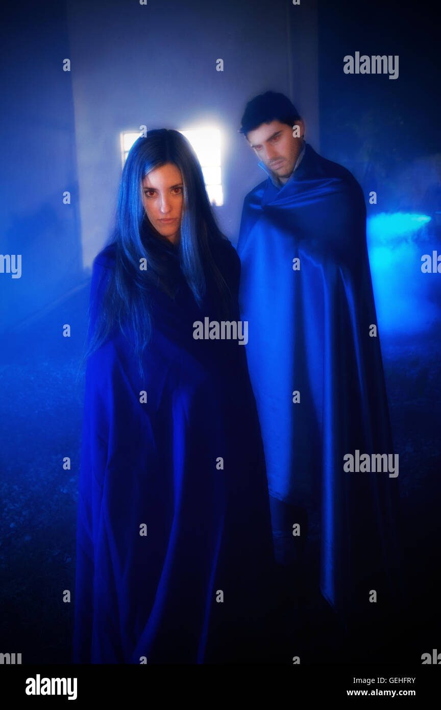 Couple wearing blue robes with a spooky attitude Stock Photo - Alamy