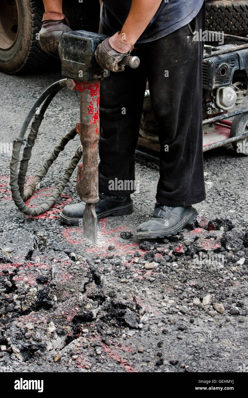 Belgrade, Serbia -  June 21, 2016: Worker jackhammering street. Shot from the waist down. Stock Photo