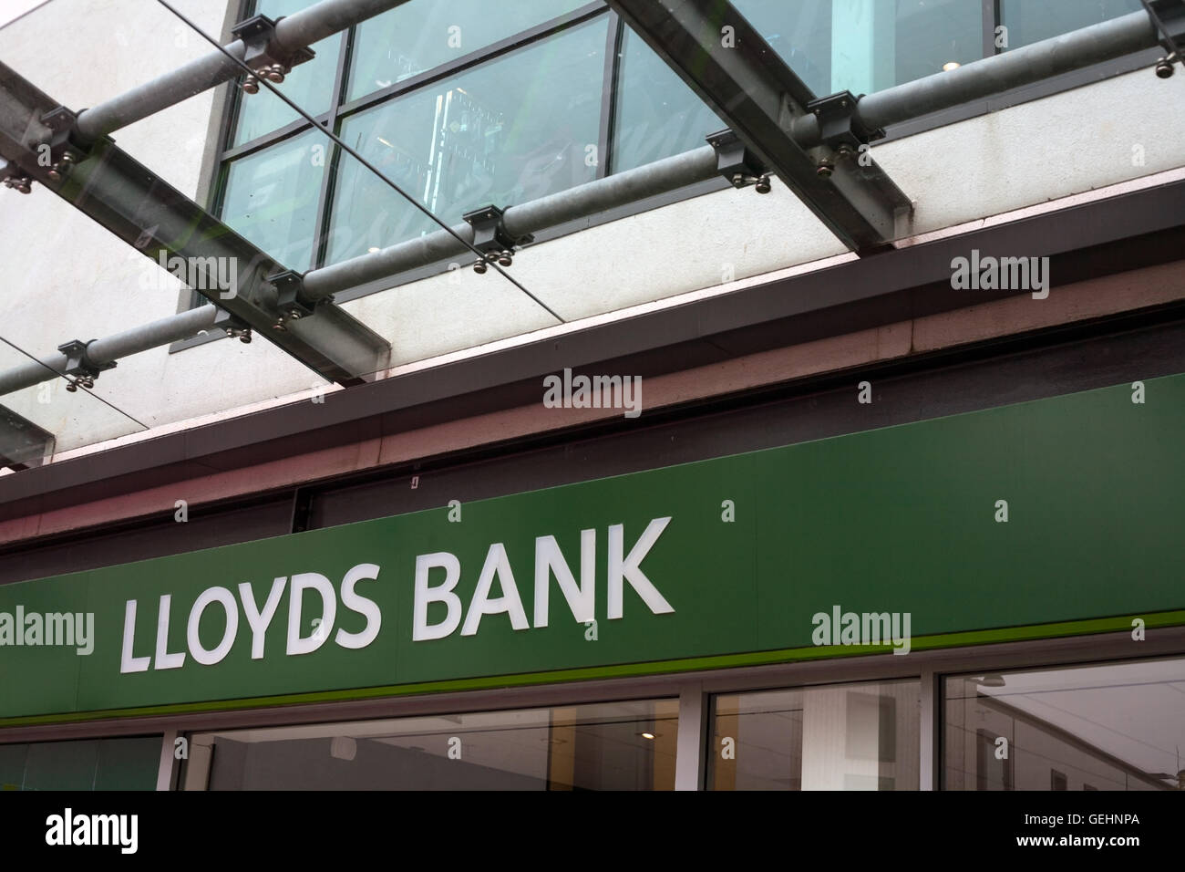 Lloyds Bank name sign. The outside of a local branch of Lloyds bank store front archictectural detail with new branding. Stock Photo