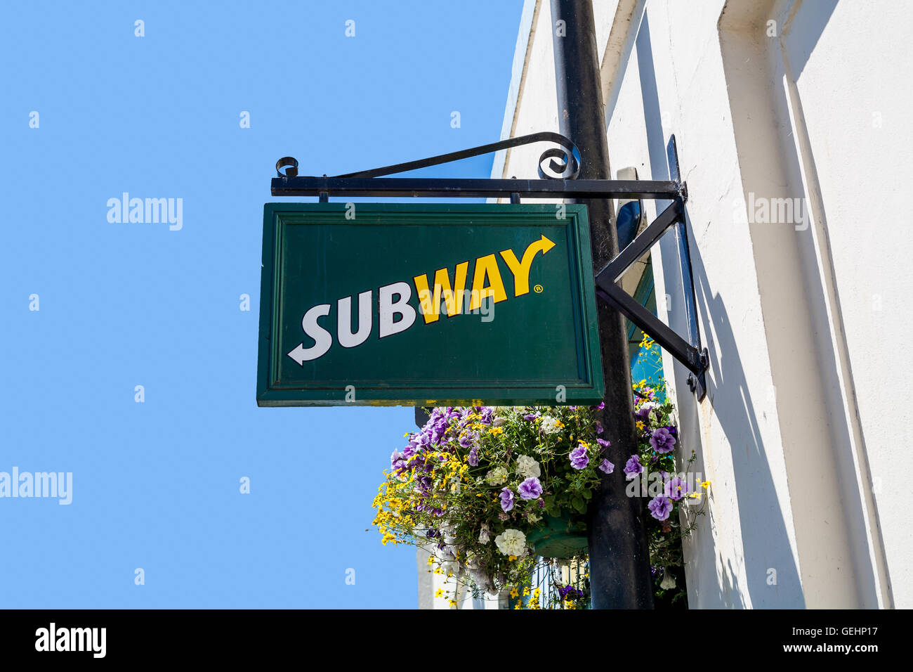 TRURO, CORNWALL, UK - JULY 17, 2016: Subway store sign on white wall with blue sky. Truro high street fast food outlet. Stock Photo