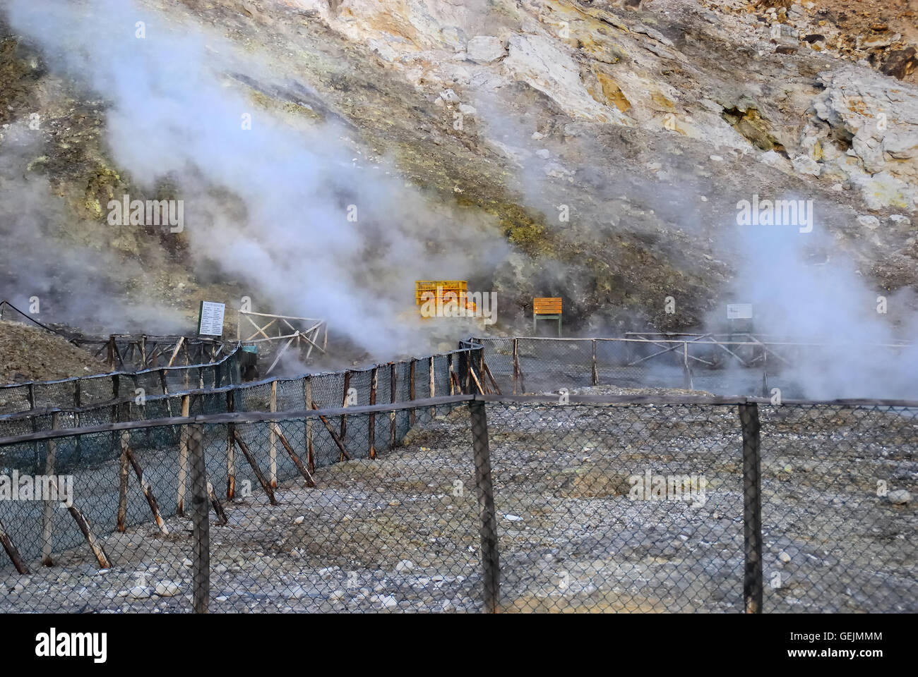 Campi Flegrei, Campania, Italy. Solfatara volcano.Gran fumarola (Biggest fumarole) is the name of the main fumarole of the Solfatara with water vapor temperatures reaching approx. 160° C. Within the mouth are certain salts contained in the vapor condense, among which realgar (As S), cinabro (Hg S) and arsenic trisulphide (As2 S3) which give a yellow-reddish colour to the surrounding rocks; solfridric acid (H2S) is also present, by the distinguishing 'rotten egg' smell. The area of the Bocca Grande (Large Mouth) was called by the Ancients “Forum Vulcani” that is the dwelling of the god of Fire. Stock Photo