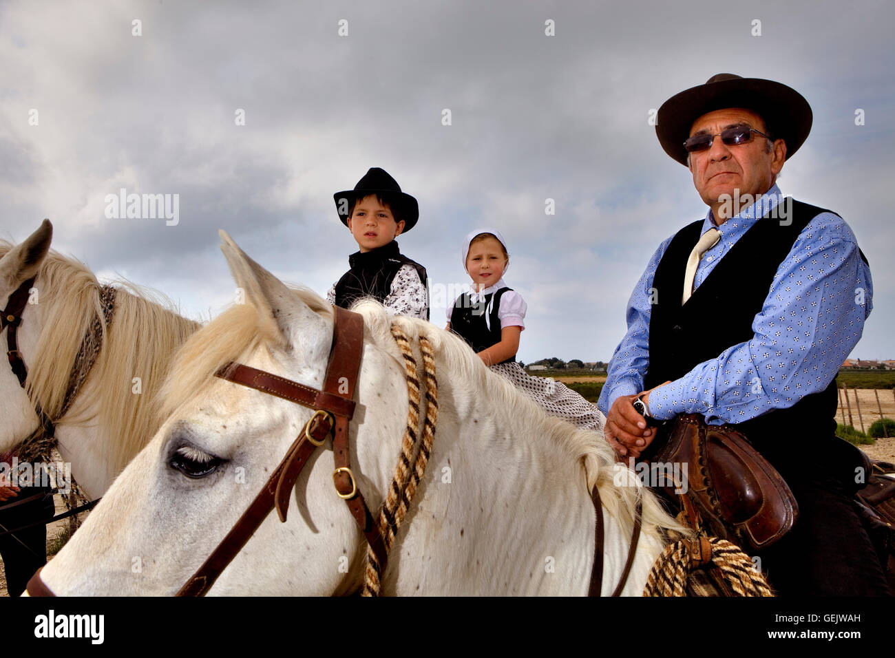 Children in traditional dress and Gardian (horseman that works with bull of  Camargue).Celebration of Day in memory of the Marqui Stock Photo - Alamy