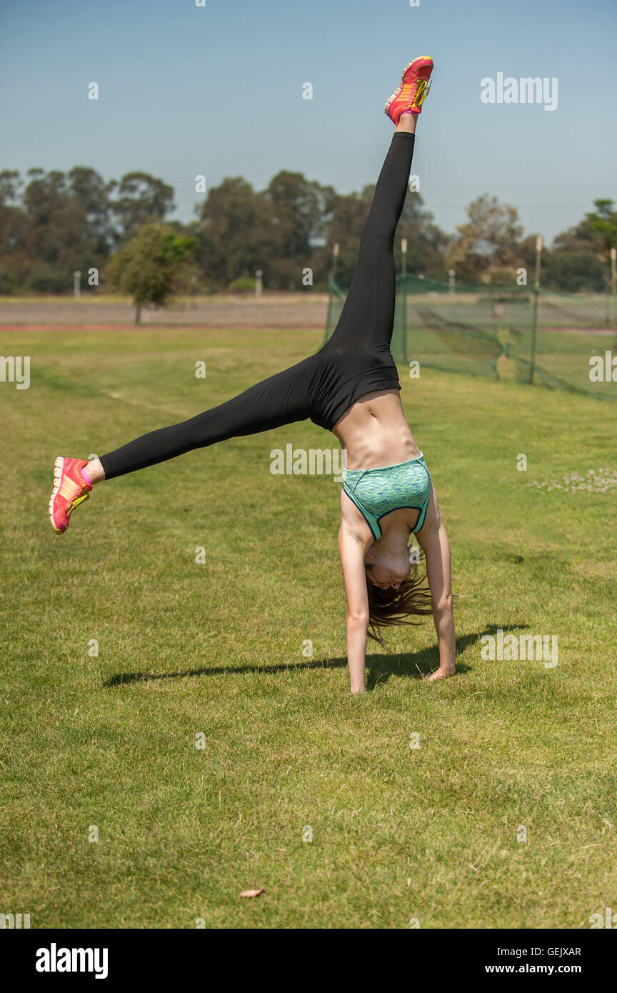Muscular teen athlete finishing her cartwheel Stock Photo