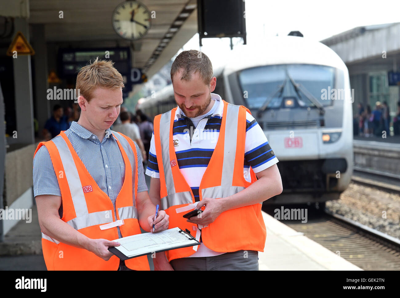 Hanover, Germany. 22nd July, 2016. Deutsche Bahn hub coordinators Florian Czeski and Kay Doerries (L-R) document the arrival and departure times of IC and ICE trains on a platform at the central train station in Hanover, Germany, 22 July 2016. Photo: Holger Hollemann/dpa/Alamy Live News Stock Photo