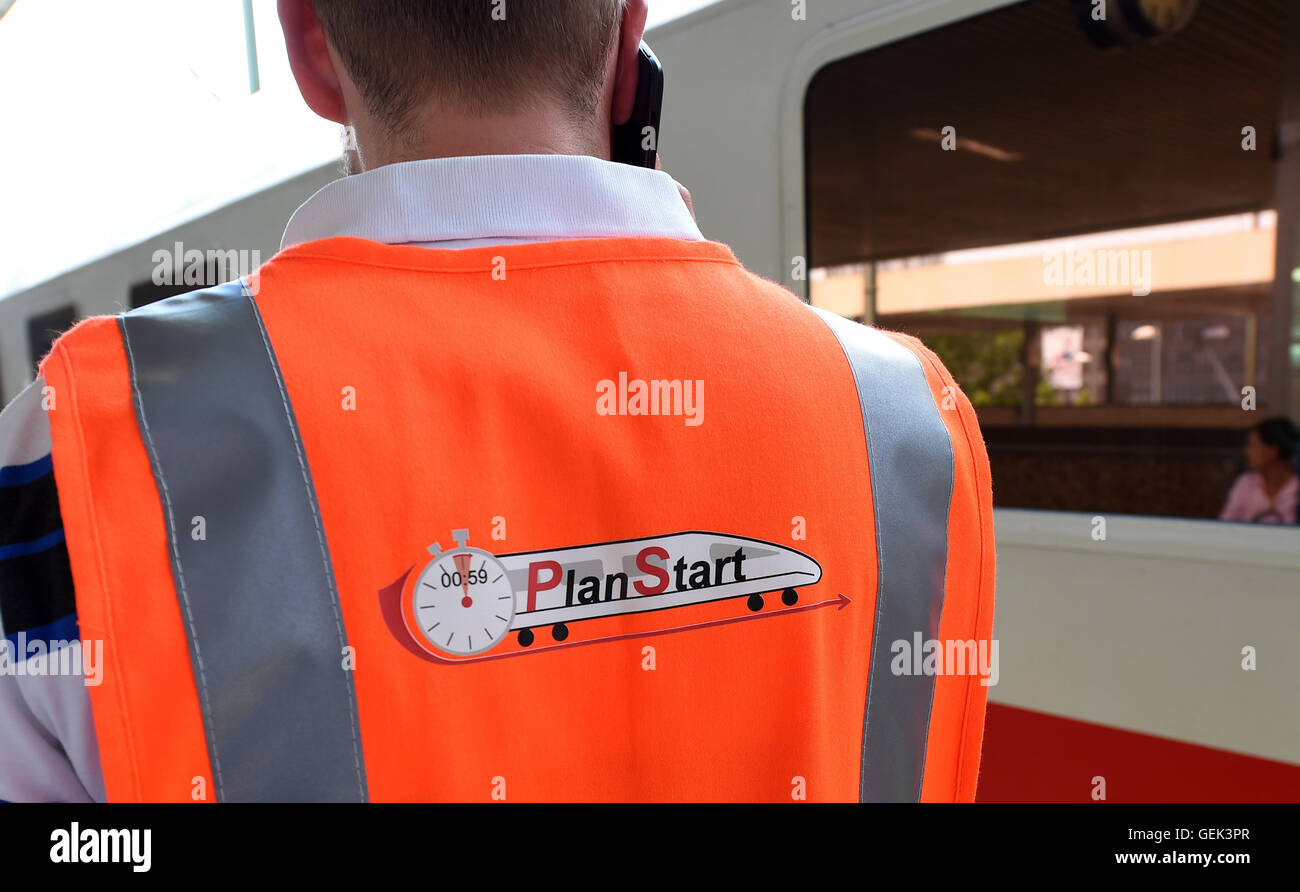 Deutsche Bahn hub coordinator Kay Doerries wears a vest written with 'PlanStart' on a platform at the central train station in Hanover, Germany, 22 July 2016. Doerries is documenting the arrival and departure times of IC and ICE trains. Photo: Holger Hollemann/dpa Stock Photo