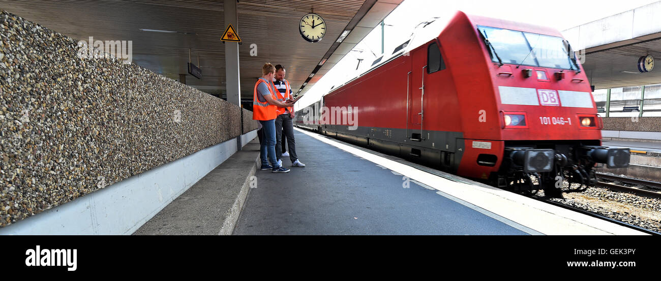 Deutsche Bahn hub coordinators Florian Czeski and Kay Doerries (L-R) document the arrival and departure times of IC and ICE trains on a platform at the central train station in Hanover, Germany, 22 July 2016. Photo: Holger Hollemann/dpa Stock Photo
