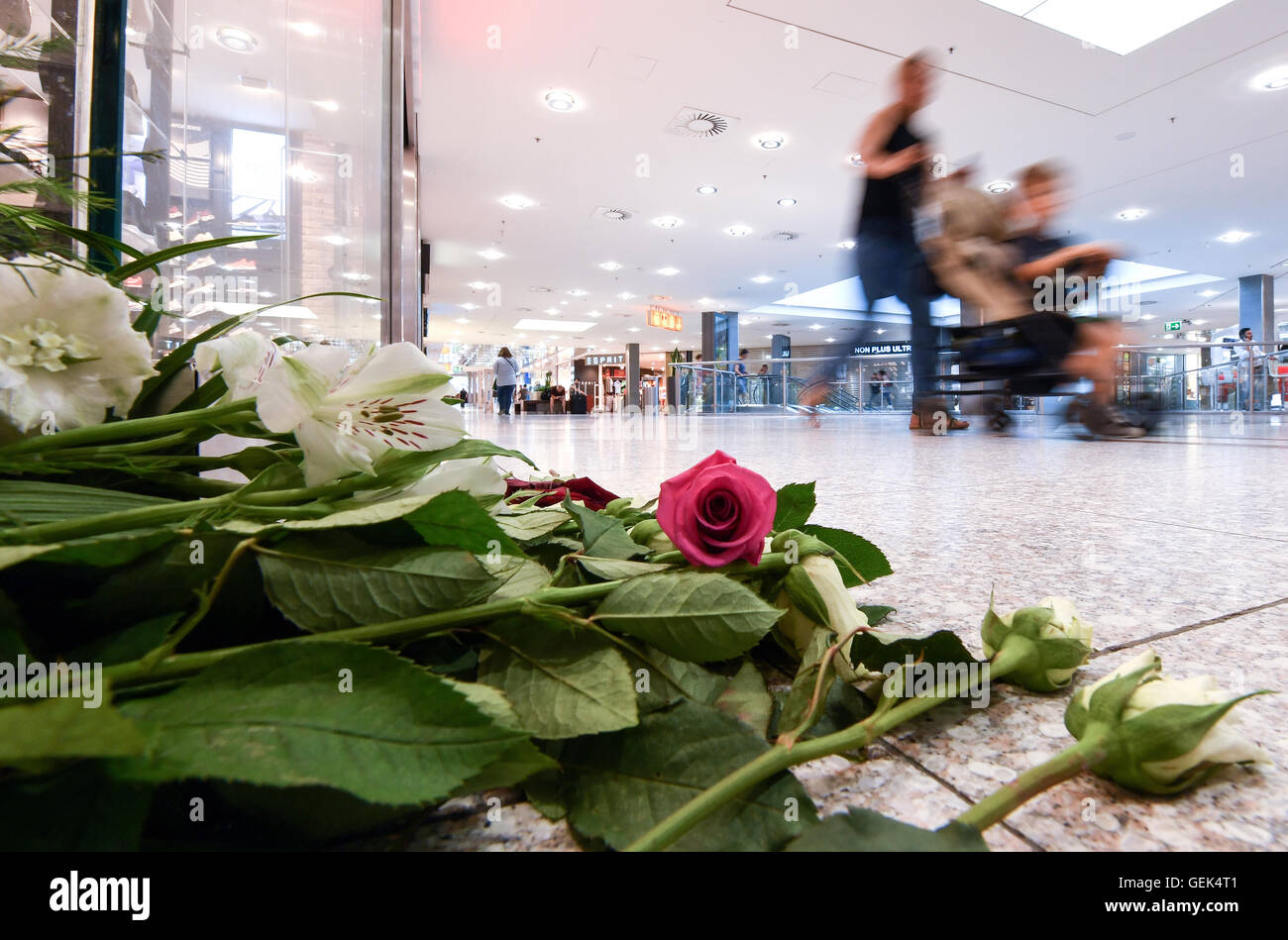 Munich, Germany. 26th July, 2016. Flowers lie on the ground in the Olympic shopping mall (OEZ) four days after a - Stock Image
