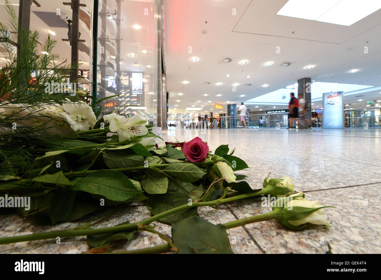 Munich, Germany. 26th July, 2016. Flowers lie on the ground in the Olympic shopping mall (OEZ) four days after a - Stock Image