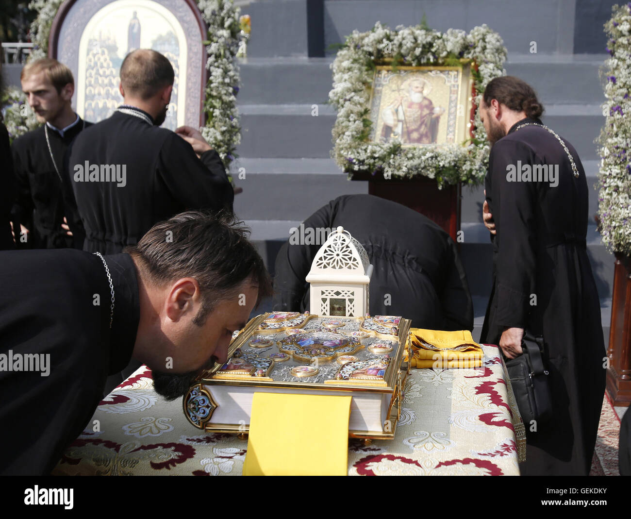 Kiev, Ukraine. 27th July, 2016. Orthodox priest of Moscow Patriarchy kisses the Holy Writ at a prayer ceremony at the St. 27th July, 2016. Vladimir's Hill, marking the 1028th anniversary of the Baptism of Kievan Rus in Kiev on July 27, 2016. Credit:  Anatolii Stepanov/ZUMA Wire/Alamy Live News Stock Photo