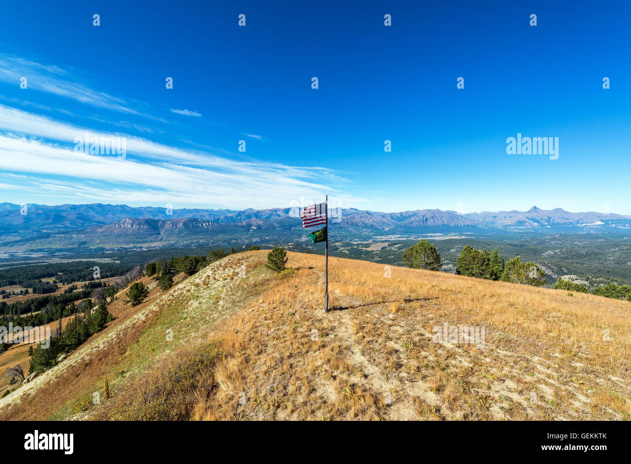 Forest Service and American flag flying over dramatic landscape view of the Absaroka Mountains just outside of Yellowstone Natio Stock Photo