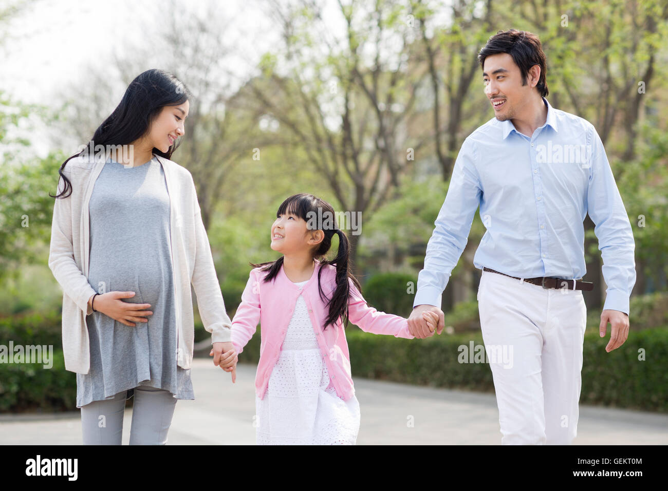 Happy young Chinese family holding hands walking Stock Photo - Alamy
