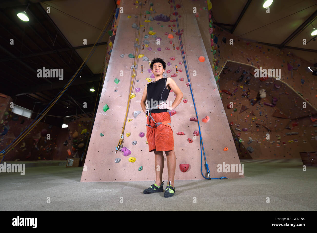 Japanese climbing athlete getting ready to climb gym wall Stock Photo