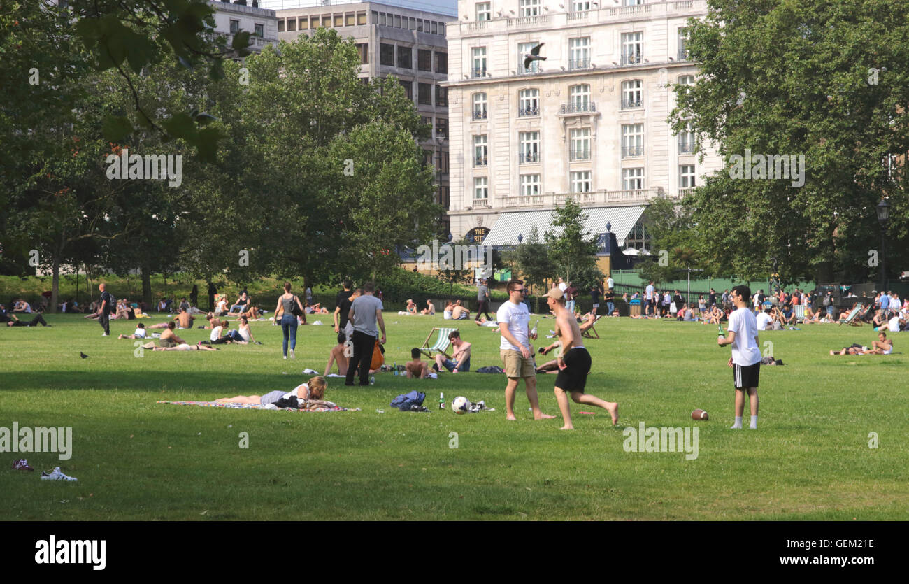 People relaxing in Green Park Piccadilly London in the July 2016 heatwave Stock Photo