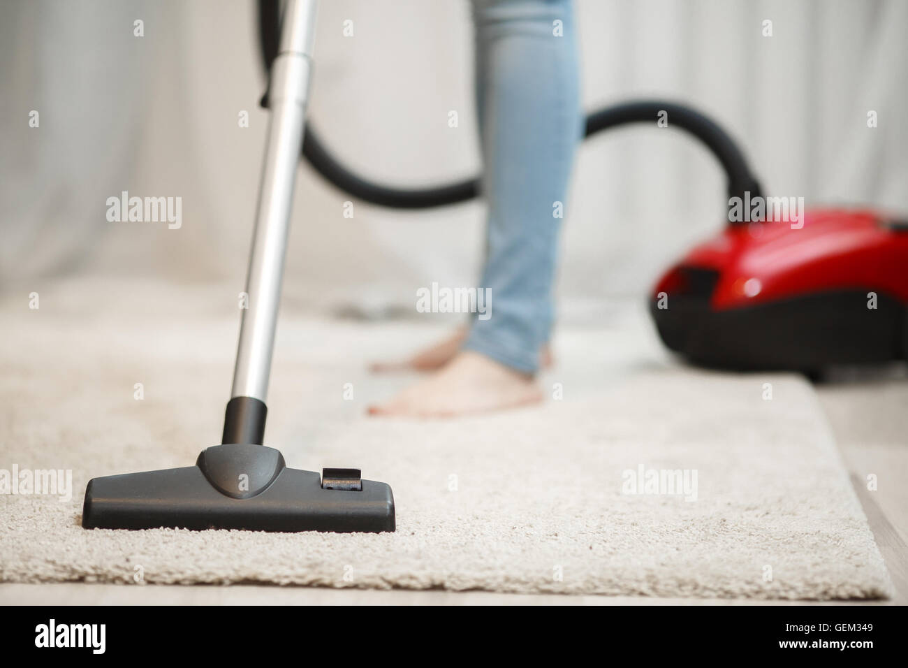 Woman cleaning carpet with vacuum cleaner Stock Photo - Alamy