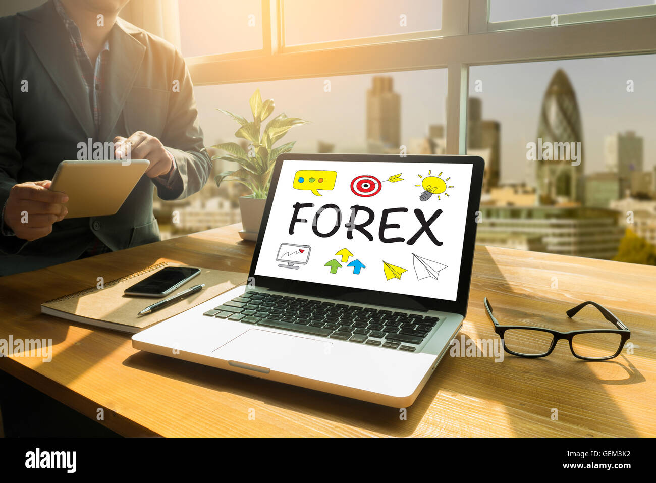 FOREX Thoughtful male person looking to the digital tablet screen, laptop screen,Silhouette and filter sun Stock Photo