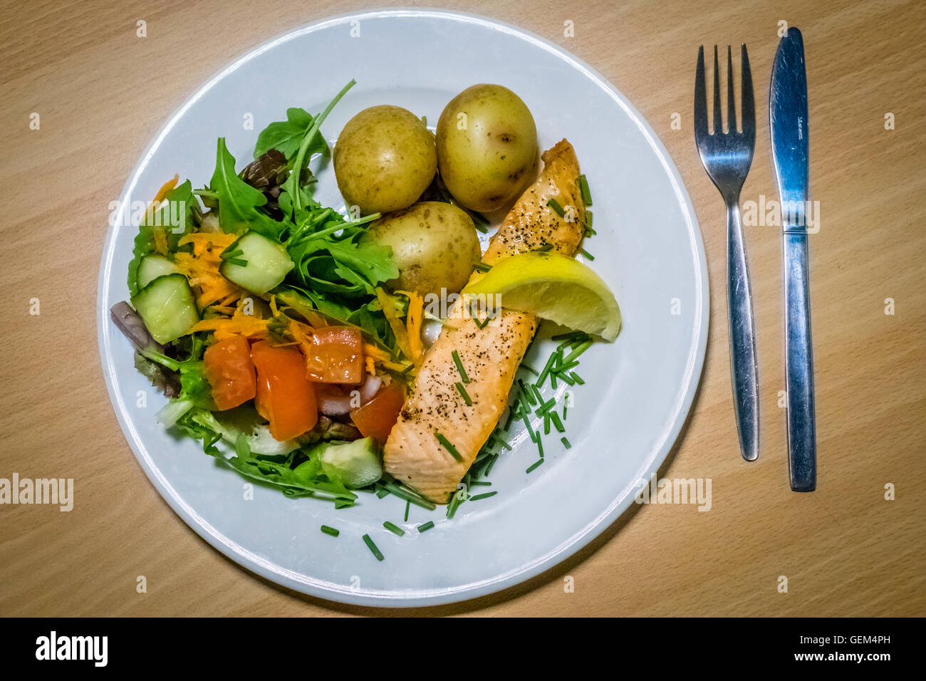Roast salmon meal served with roasted baby potatoes and tomato