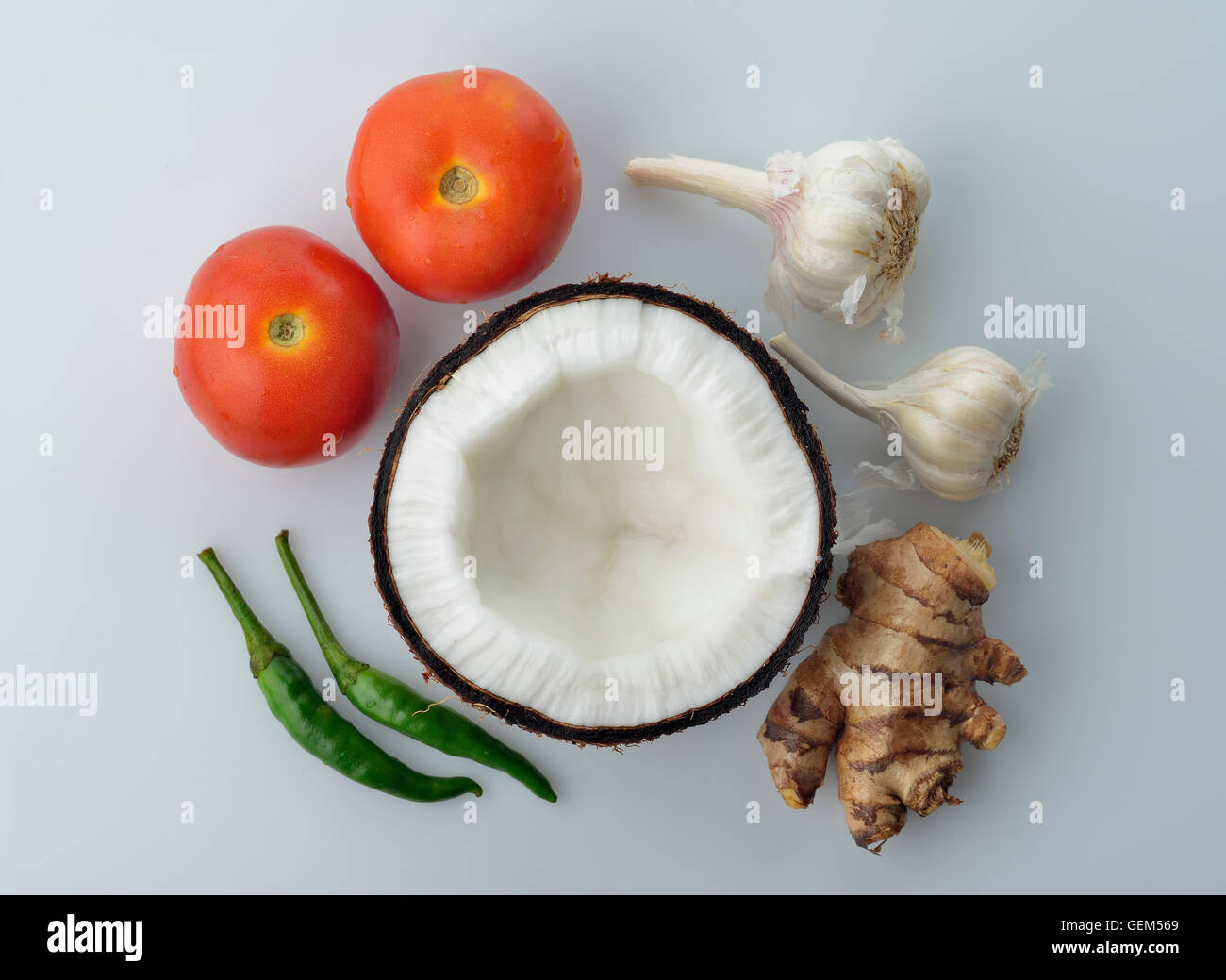 Top View of Coconut,Ginger ,Tomatoes,Garlic and Green Chili on White Background Stock Photo