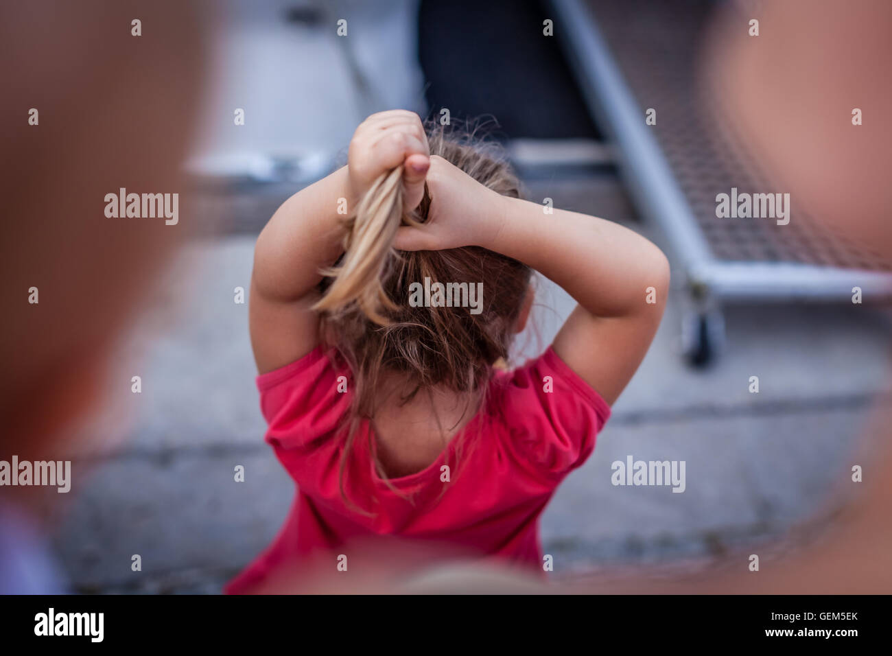 Cute young little girl adjusting her hair Stock Photo - Alamy