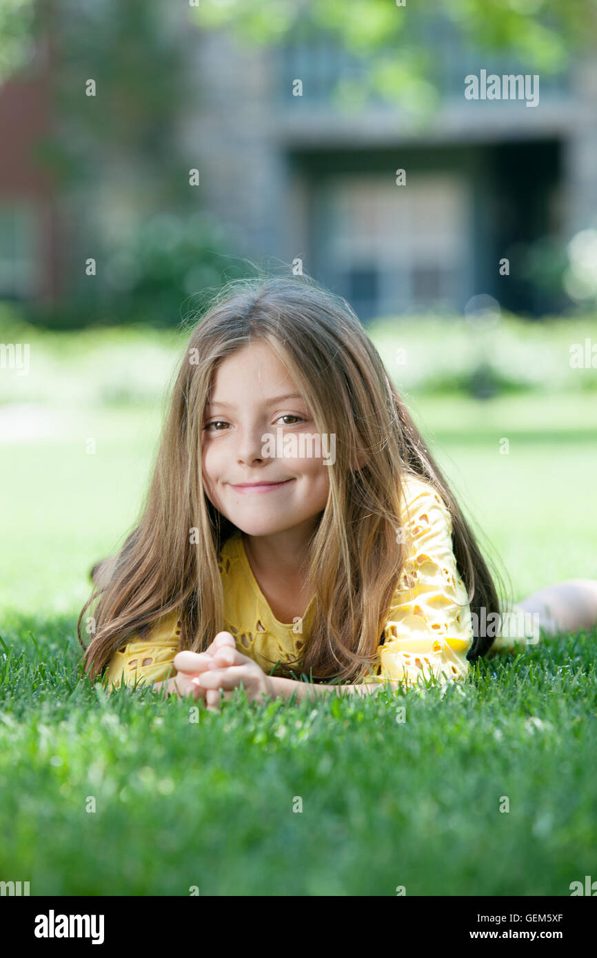 portrait of little girl laying on the grass in summer environment Stock ...