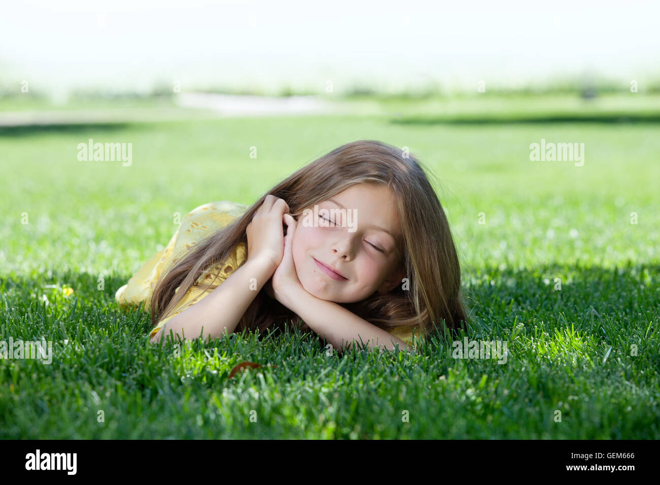 portrait of little girl laying on the grass in summer environment Stock ...