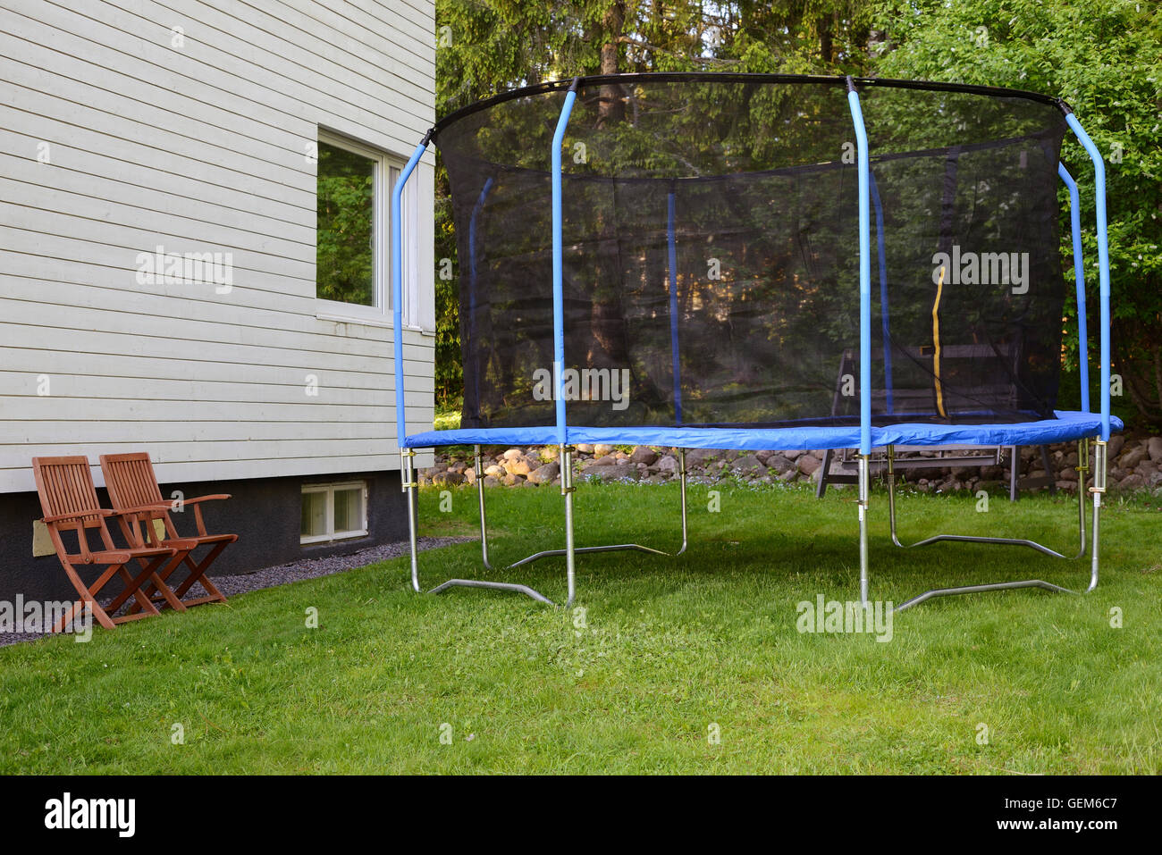 trampoline on lawn next to the house, horizontal Stock Photo