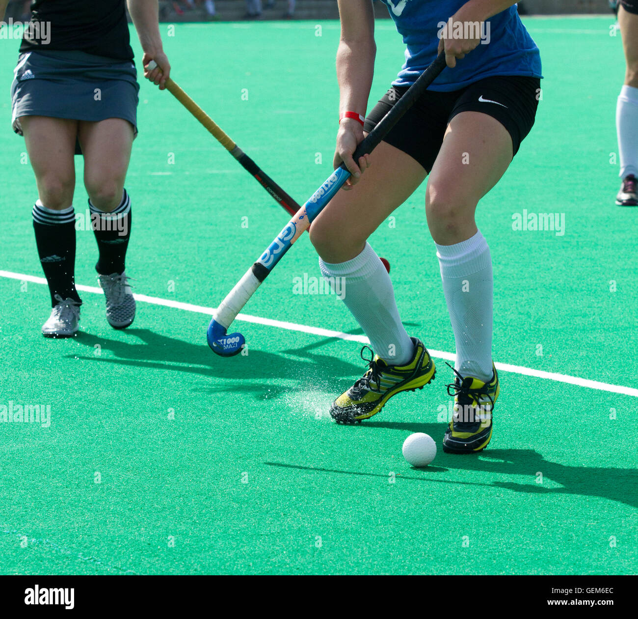 Two female field hockey players scramble for the ball Stock Photo