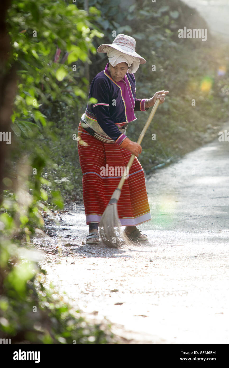 View of thai woman in authentic dress is cleaning street Stock Photo