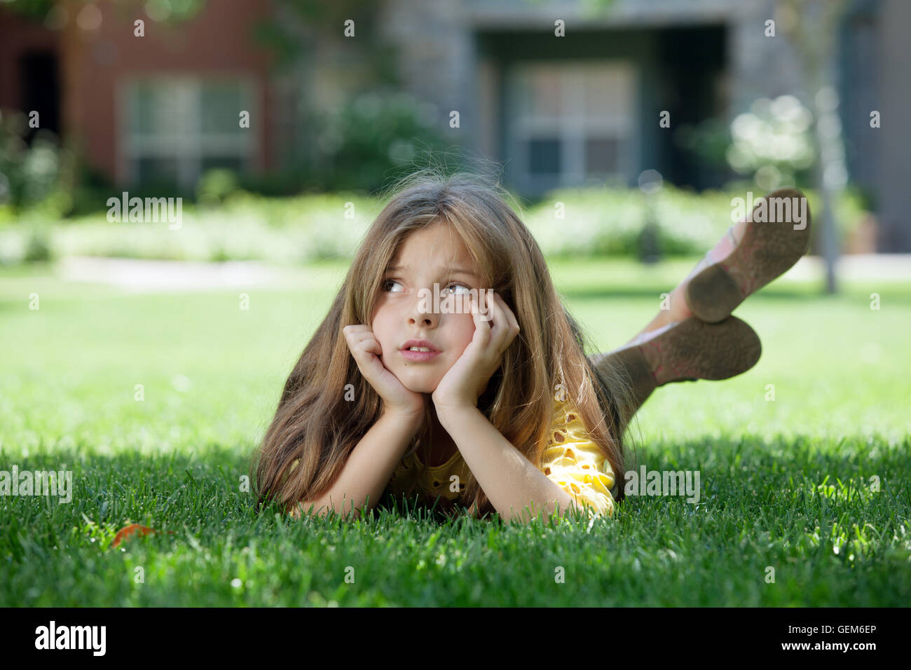 portrait of little girl laying on the grass in summer environment Stock ...