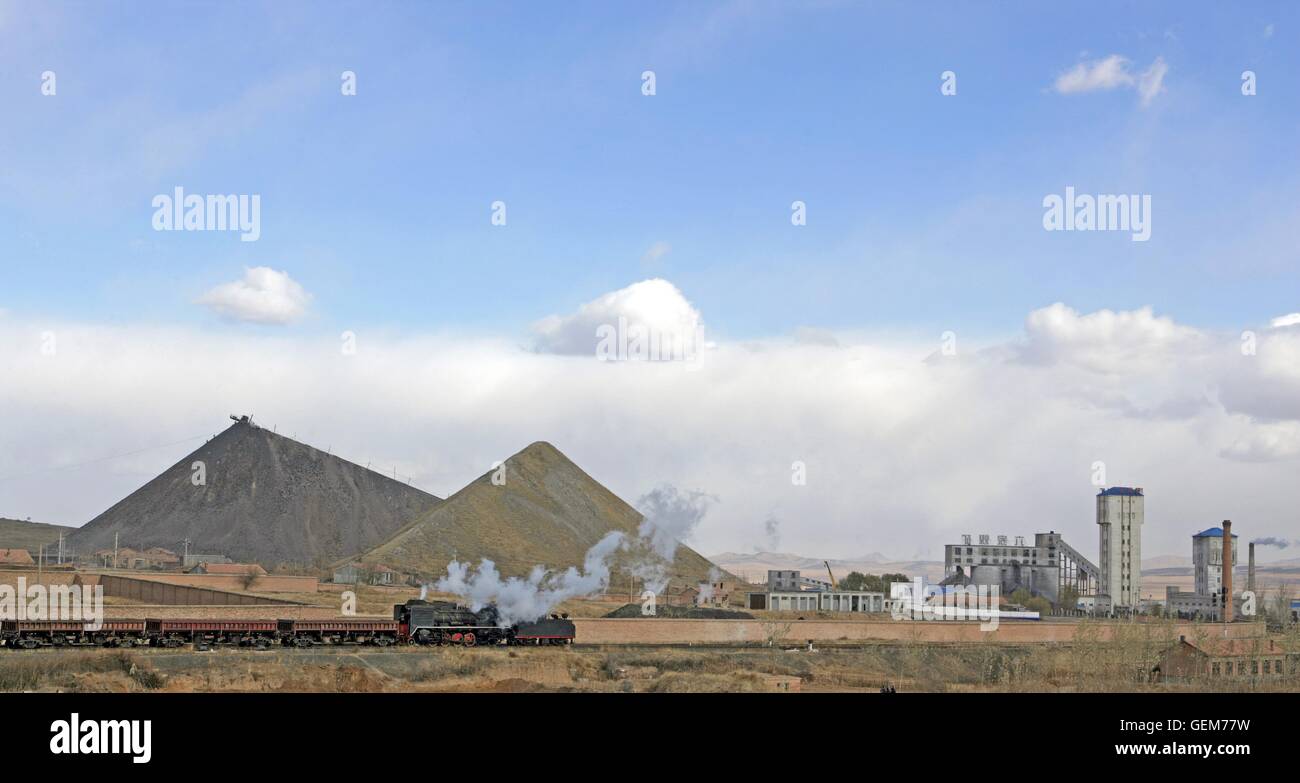 Industrial Landscape at Pingzhuang. An ex China Railway’s JS Class 2-8-2 drifts between the collieries. A picture dated 2006. Stock Photo