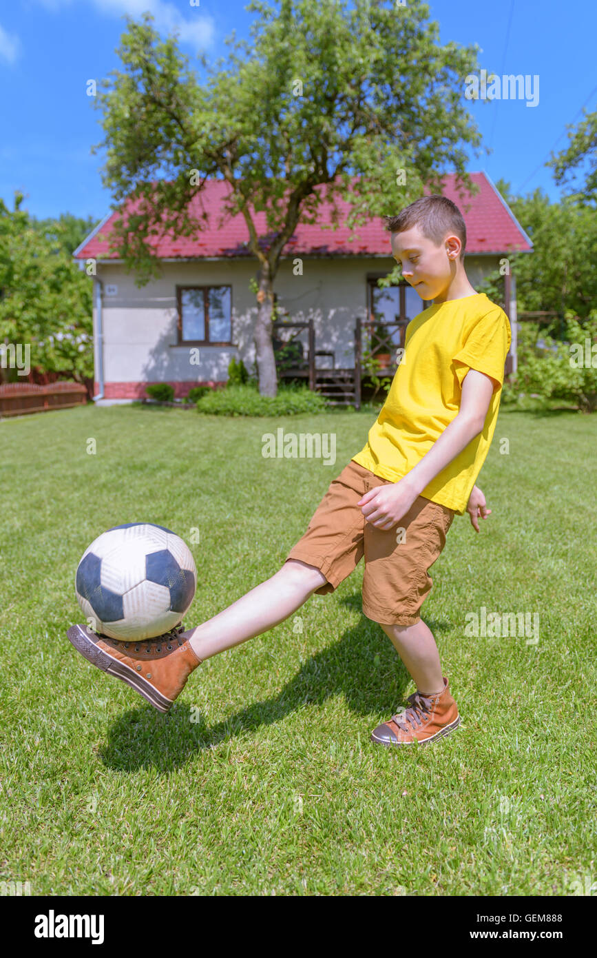 Boy with ball on green lawn. Summer time! Stock Photo