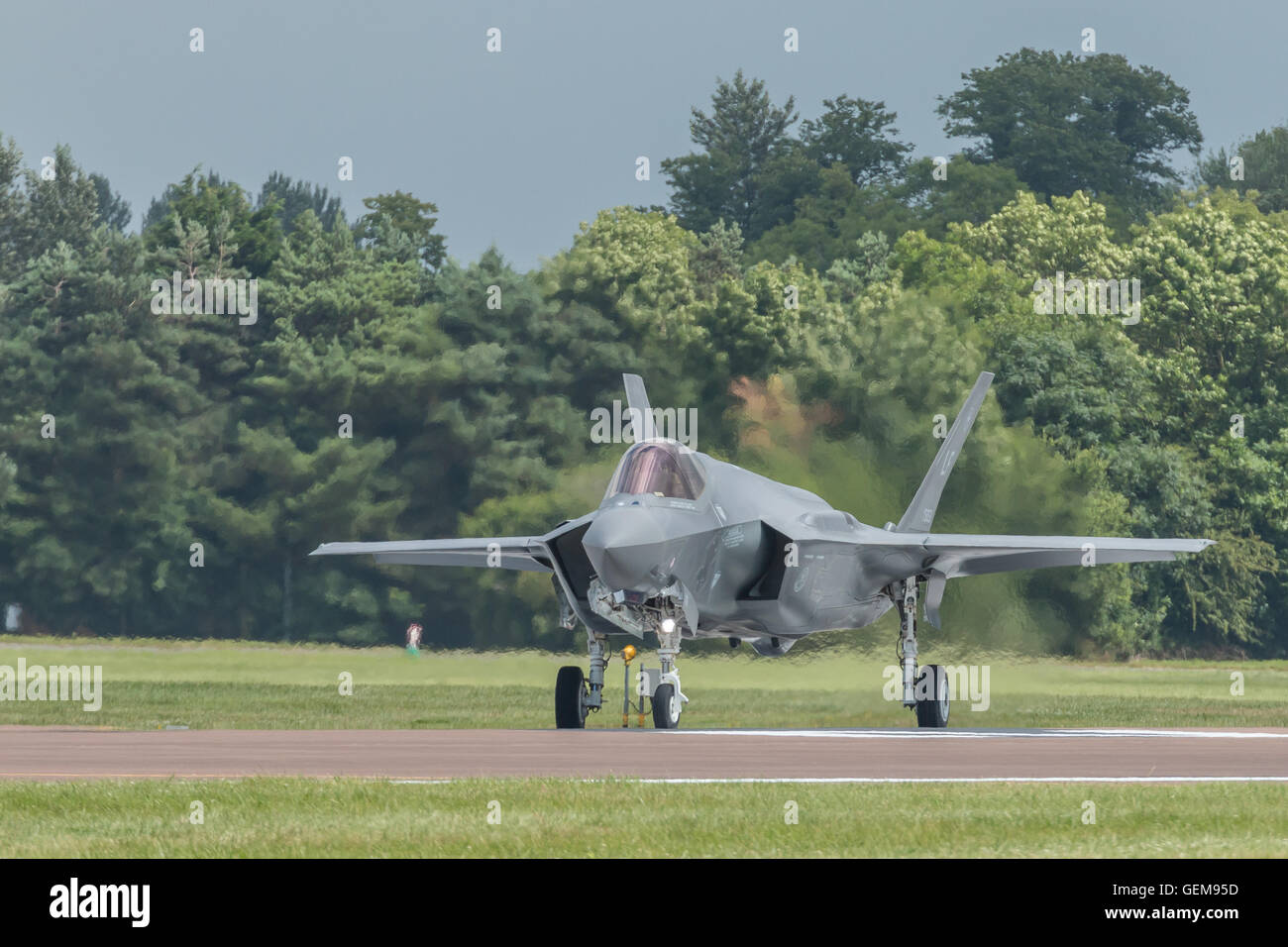F-35 Lightning 2 taxiing onto runway with heat haze rising from its afterburner. Stock Photo