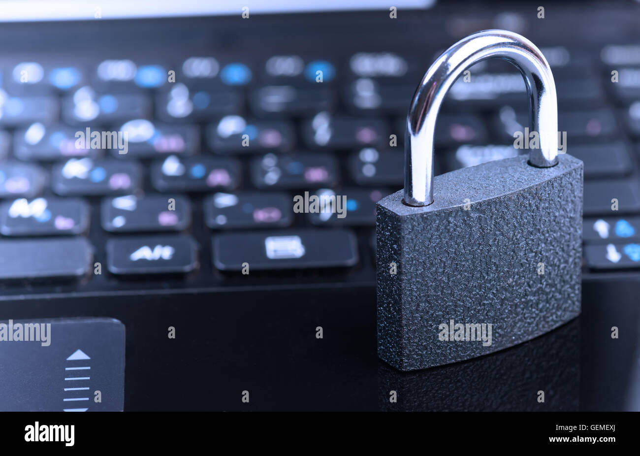 Data security concept with padlock on laptop computer keyboard. Toned in blue Stock Photo