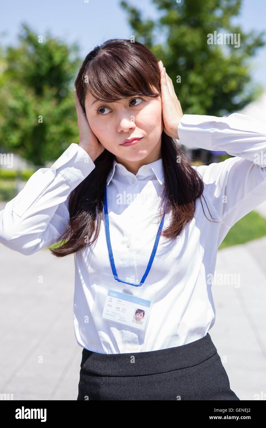 Business woman covering her ears Stock Photo