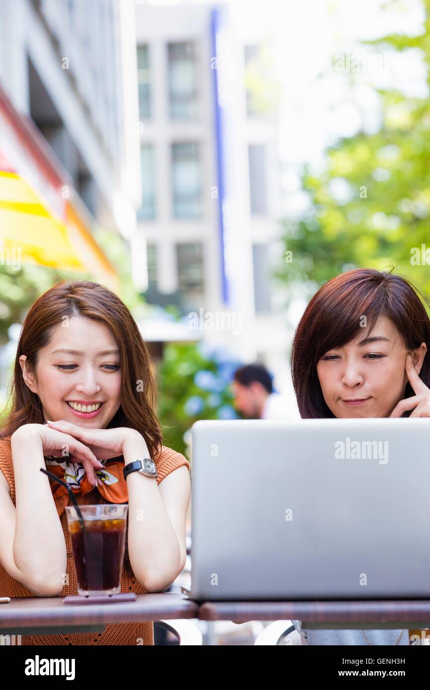 Business women using a computer at an outdoor cafe Stock Photo - Alamy