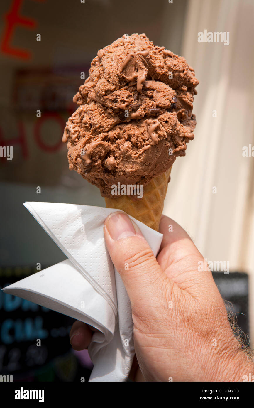 UK, England, Devon, Sidmouth, hand holding large chocolate ice cream in wafer cone Stock Photo