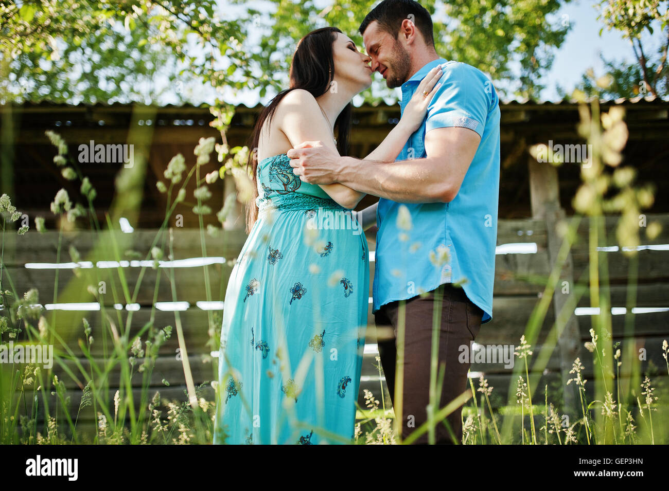Happy pregnant couple at turquoise dress on the garden Stock Photo - Alamy