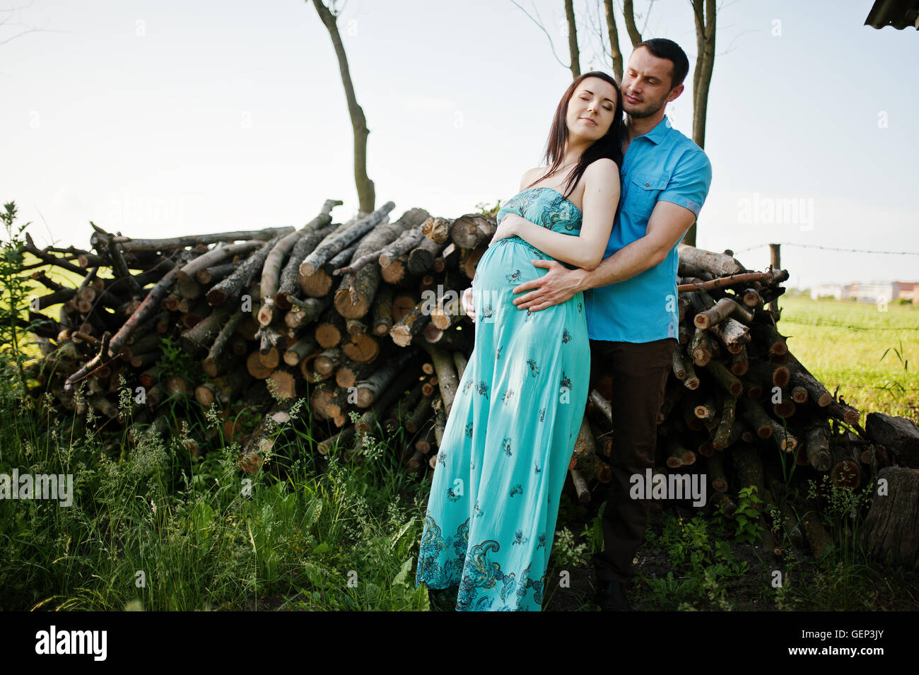 Happy pregnant couple at turquoise dress on the garden Stock Photo - Alamy