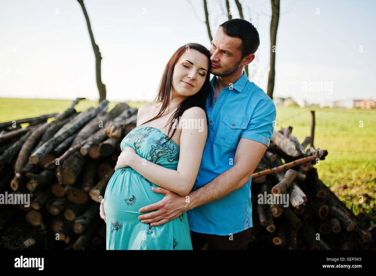 Happy pregnant couple at turquoise dress on the garden Stock Photo - Alamy