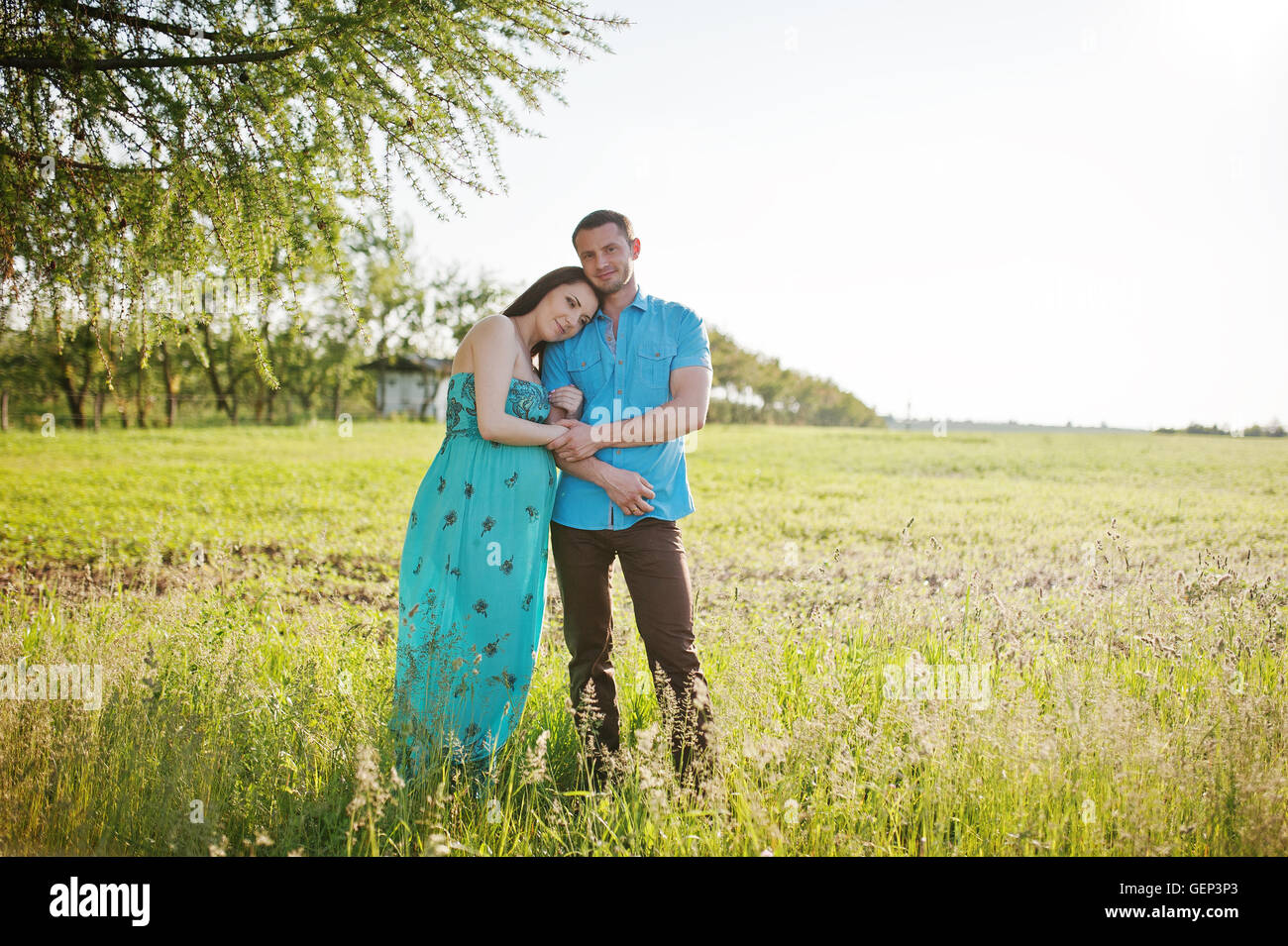 Happy pregnant couple at turquoise dress on the garden Stock Photo - Alamy