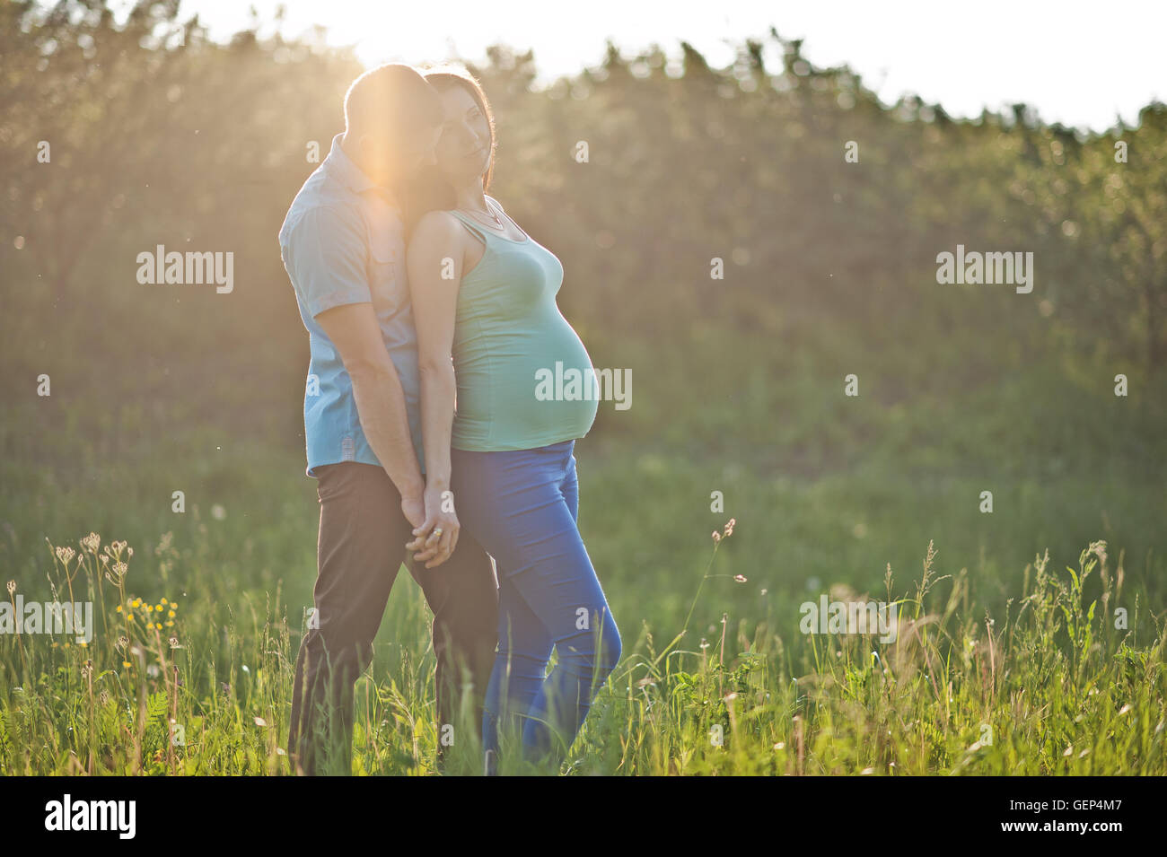 Happy pregnant couple at garden on magestic sunset Stock Photo - Alamy