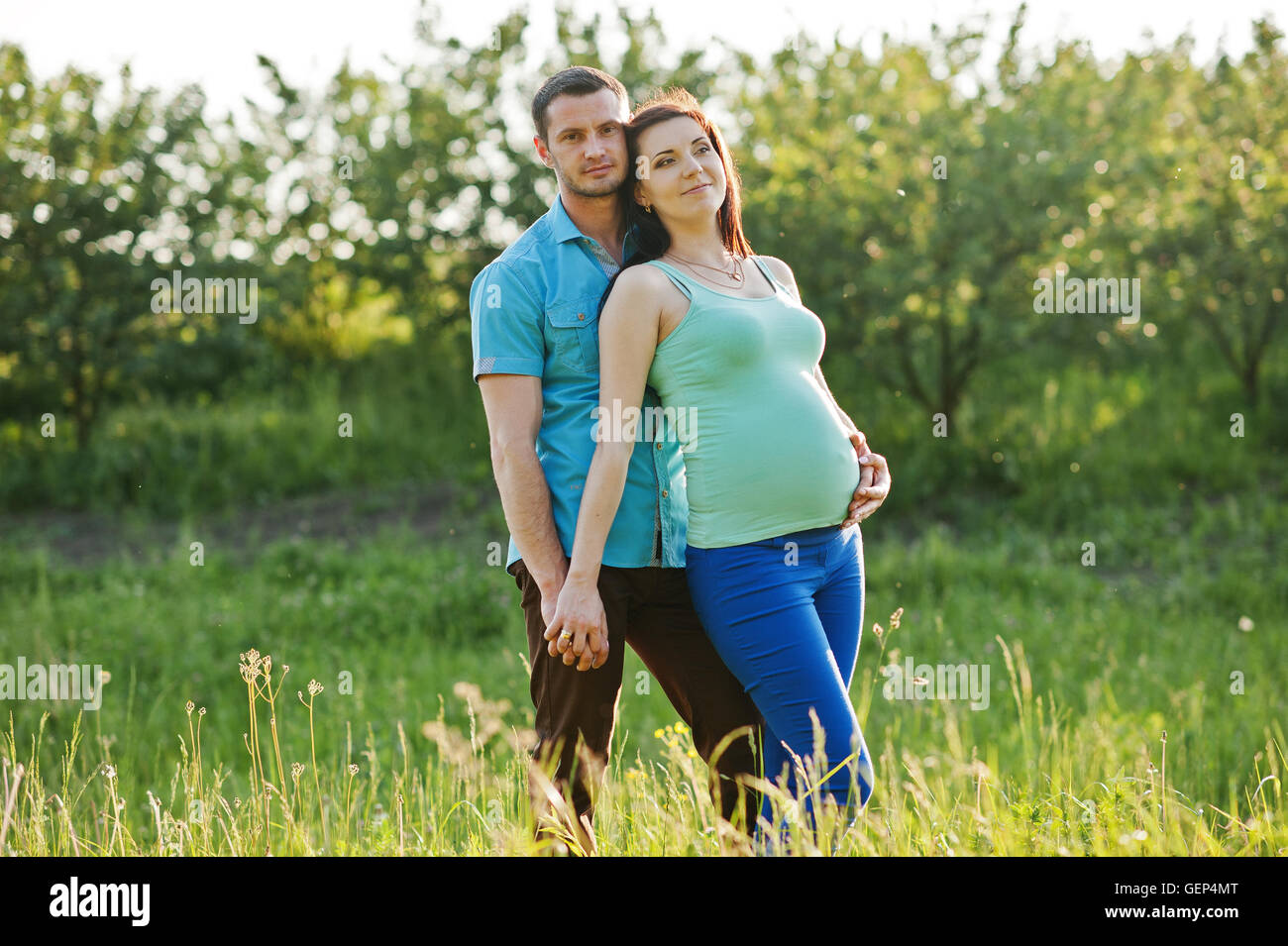 Happy pregnant couple at garden on magestic sunset Stock Photo - Alamy