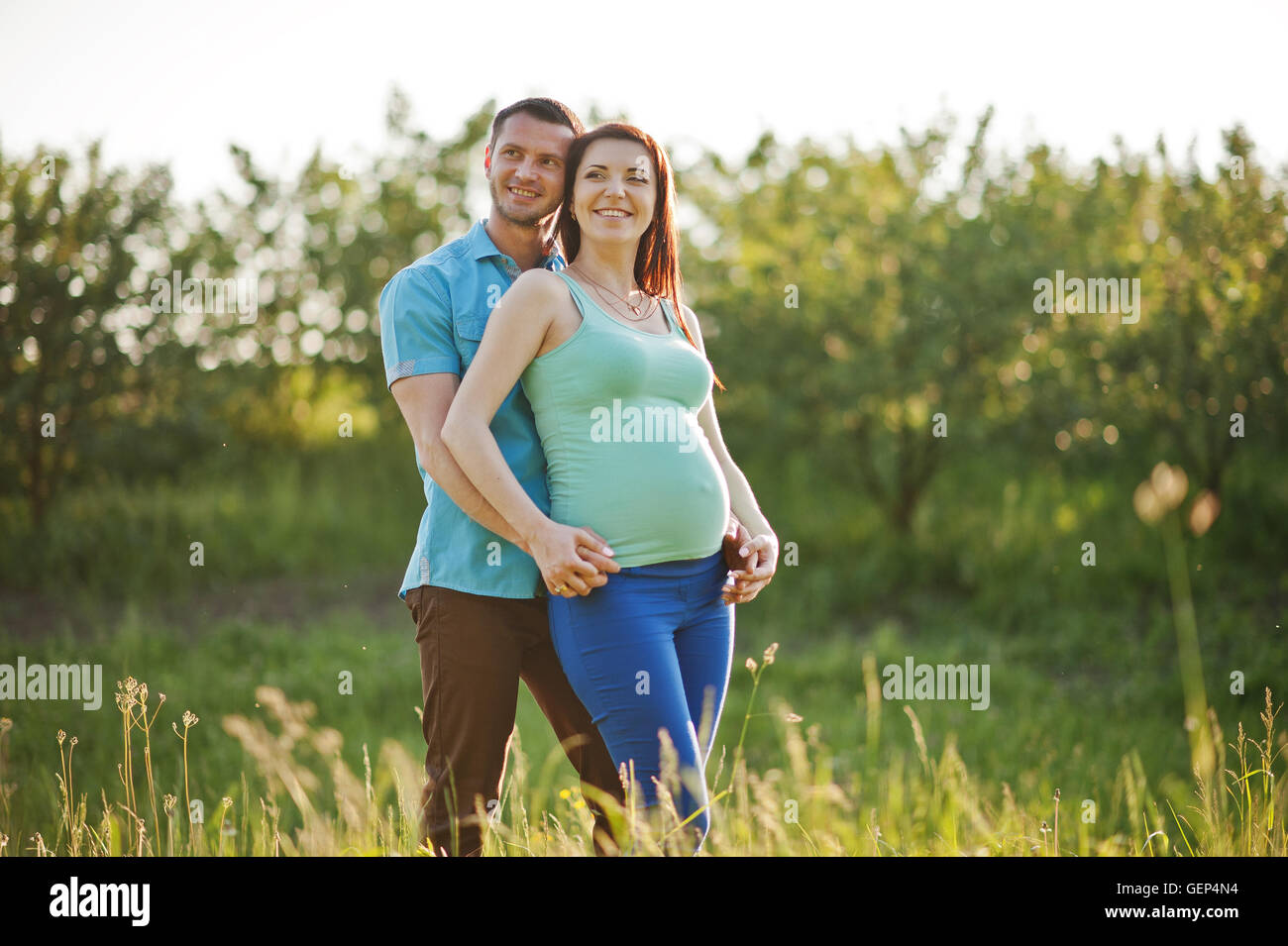 Happy pregnant couple at garden on magestic sunset Stock Photo - Alamy