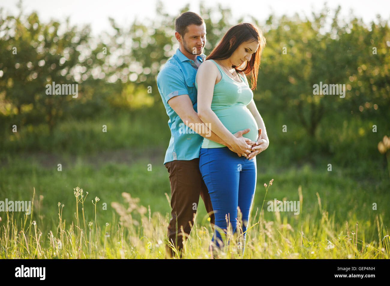 Happy pregnant couple at garden on magestic sunset Stock Photo - Alamy